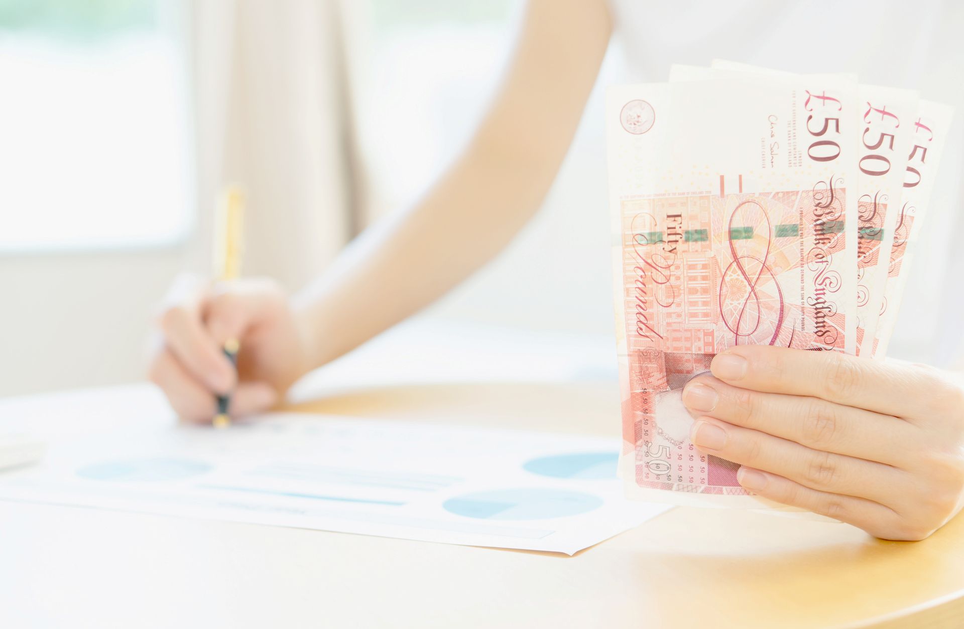 Counting UK notes on a kitchen table